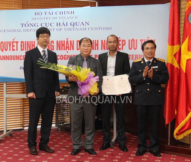 Phó Tổng cục trưởng Tổng cục Hải quan Nguyễn Dương Thái trao quyết định công nhận DN ưu tiên và tặng hoa chúc mừng đại diện SEVT ngày 3-3-2014. Ảnh: T.Bình.